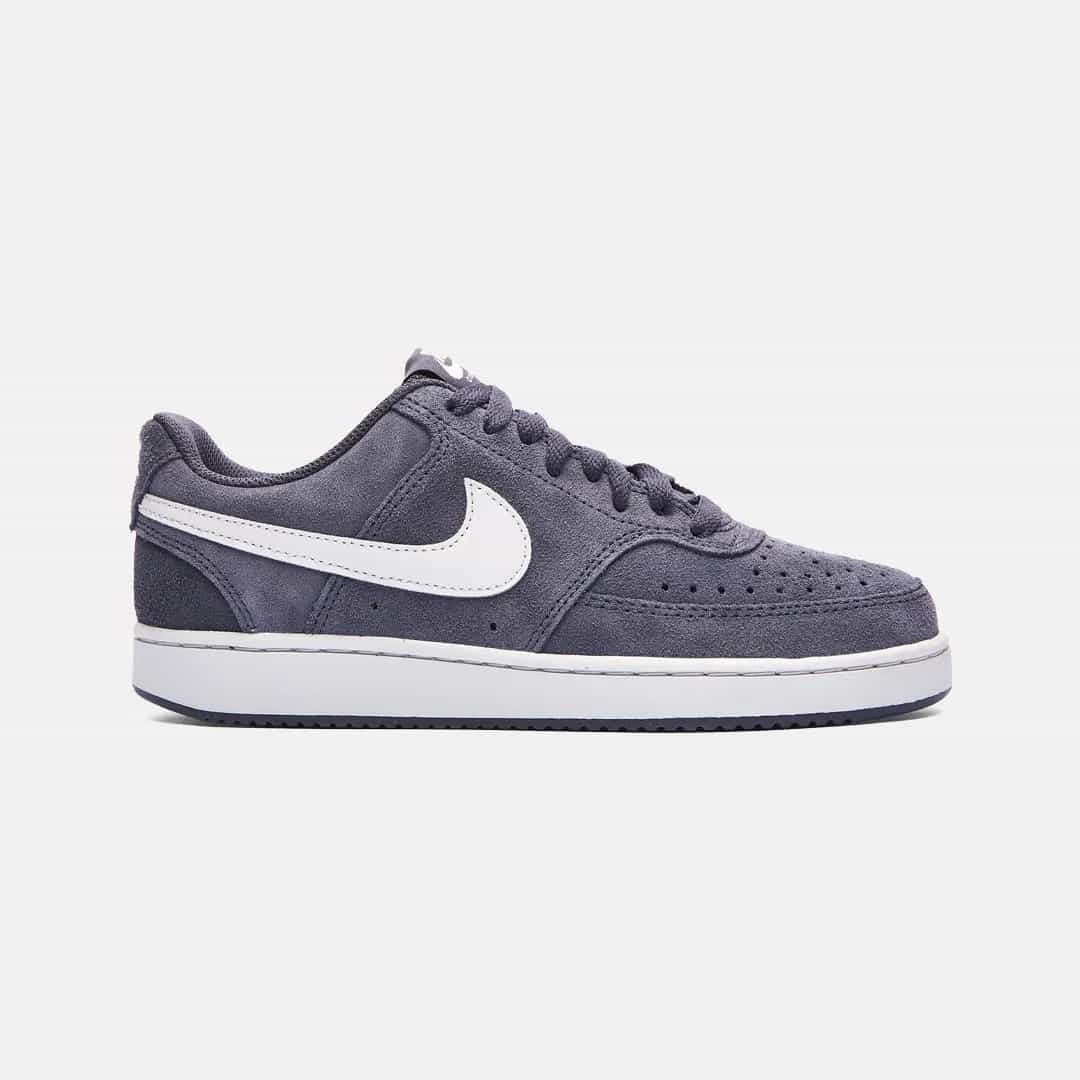 Mörkgrå Nike sneaker med vitt swoosh-emblem och vit sula, sedd från sidan på vit bakgrund.