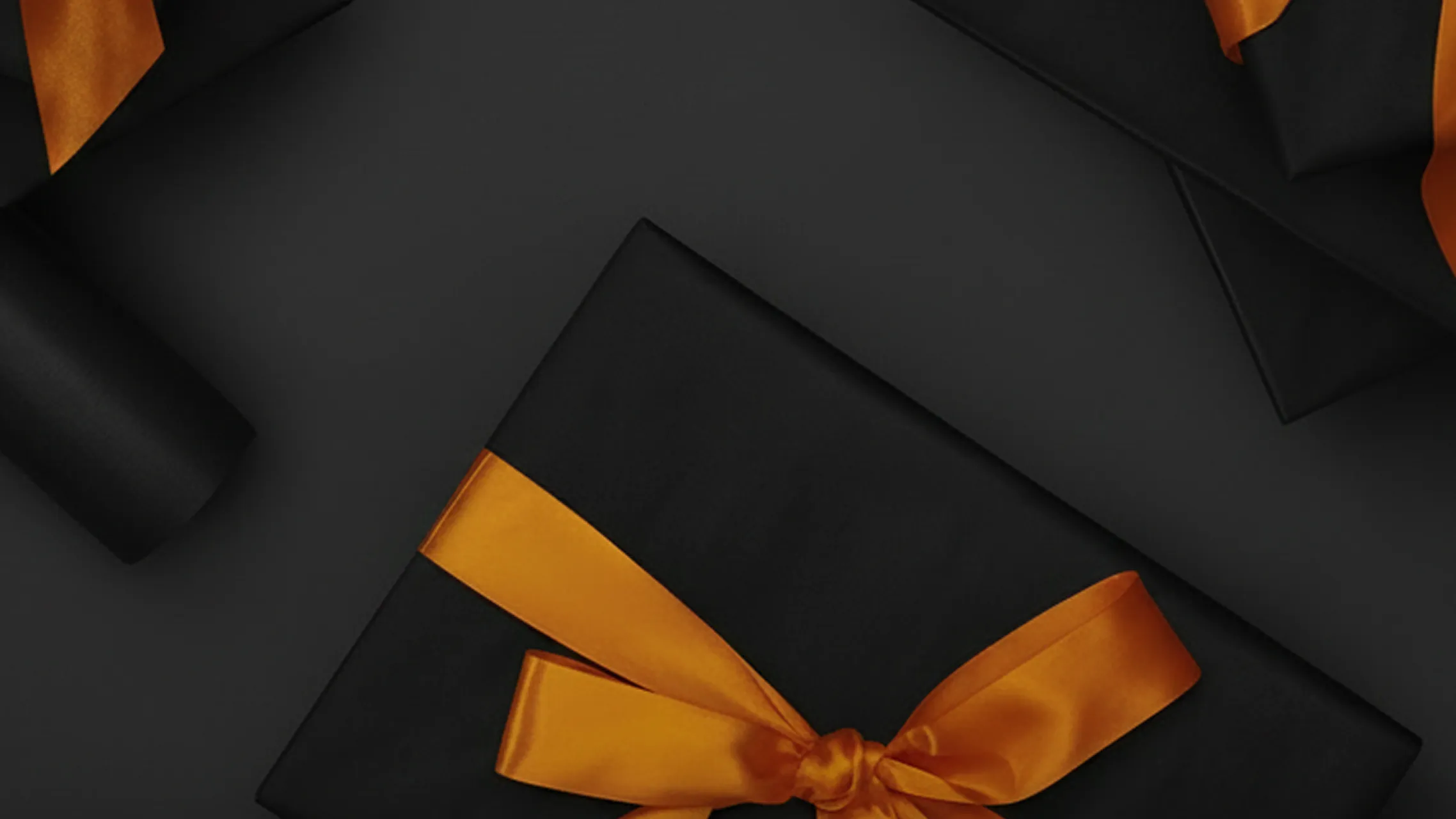 Black gifts adorned with vibrant orange ribbons on a dark background.