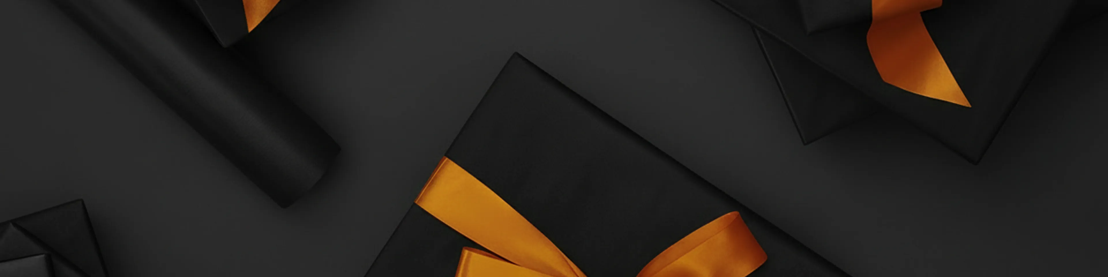 Black gifts adorned with vibrant orange ribbons on a dark background.
